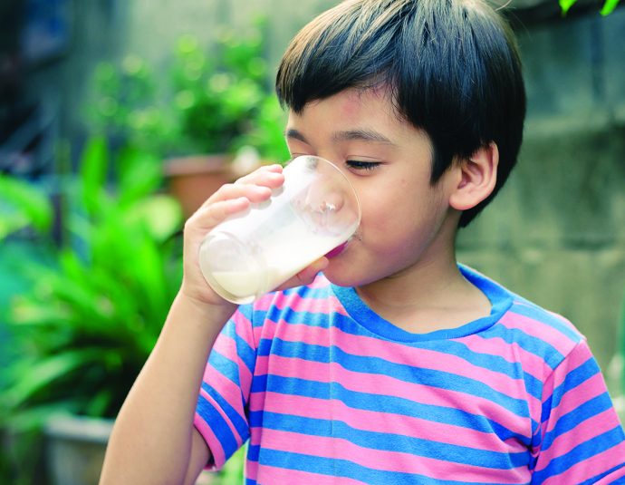 Littl boy drinking milk in the park vintage style - Positive Parenting